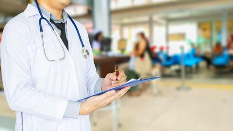 Health care, emergency room physician writing a patient illness report