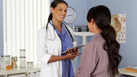 gynecologist talking to patient with tablet