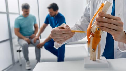 Treatment for knee injuries. Adult man with knee injury during consultation with doctor traumatologist at medical clinic