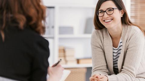 Happy woman during successful psychotherapy with counselor at clinic