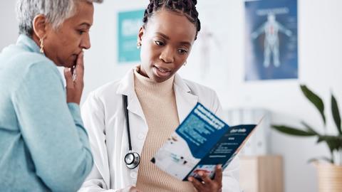 Doctor reading pamphlet to potential patient 