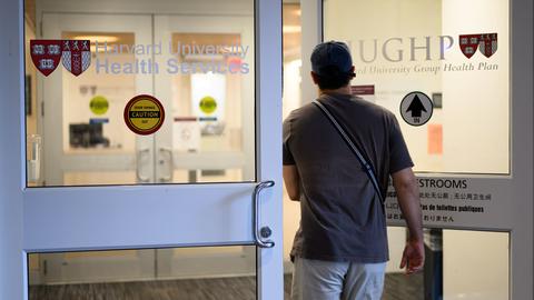 Person entering the Harvard University Health Services entrance at the 75 Mount Auburn Street entrance
