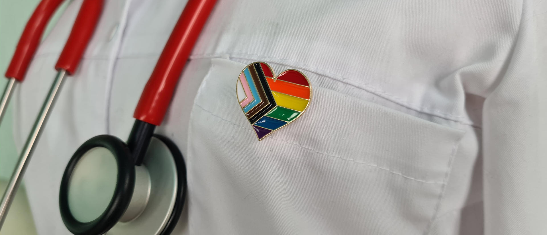Silhouette of doctor in white coat with stethoscope and LGBT badge on pocket