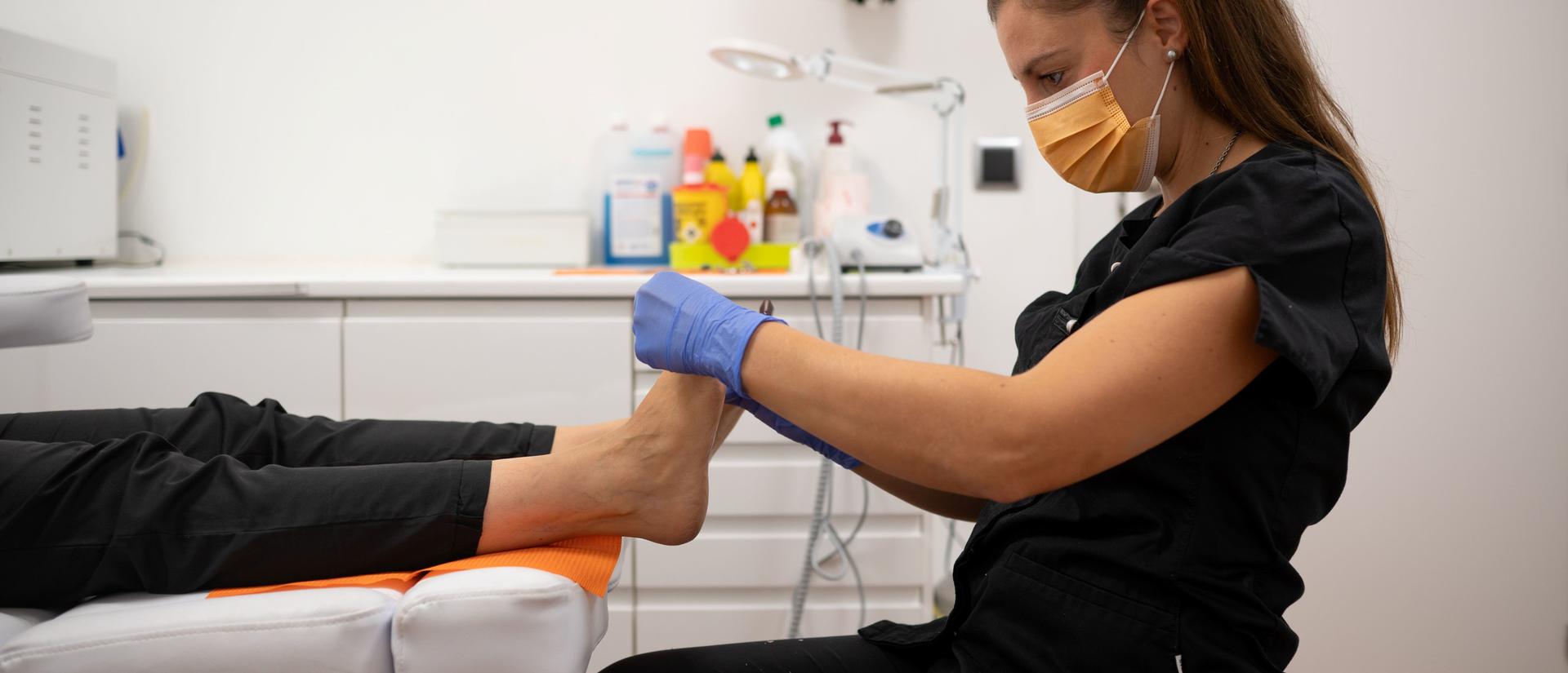 Podiatrist performing foot examination on patient in clinic 