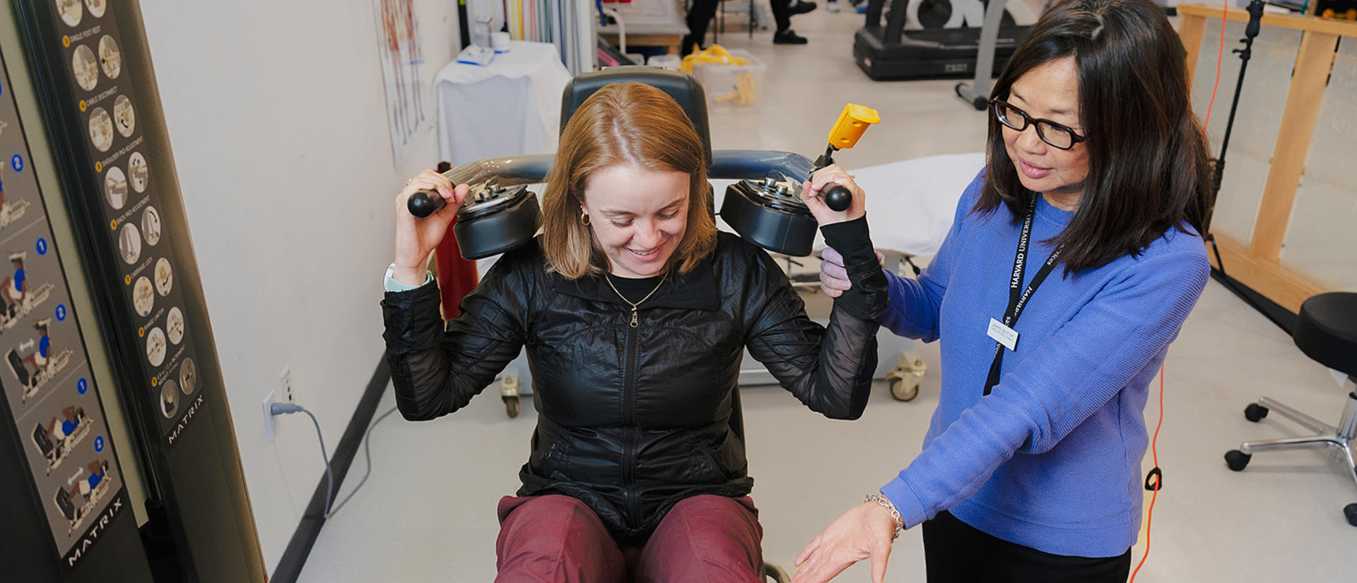 Physical therapist and patient using a machine in the PT department of HUHS