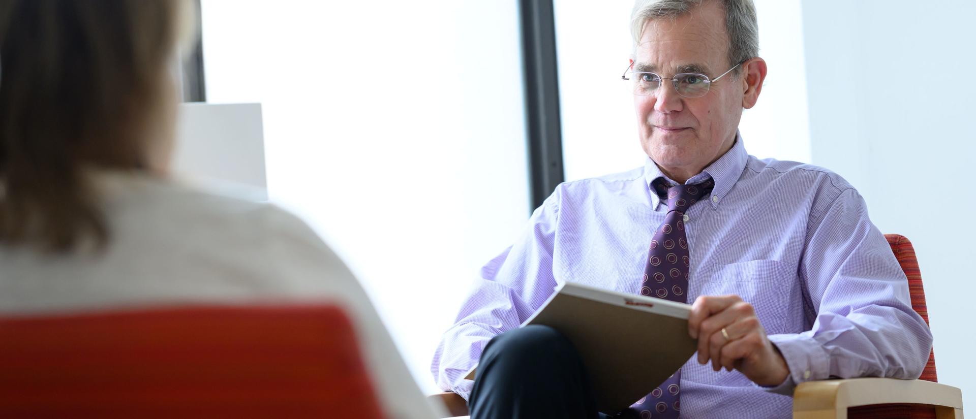 Behavioral Health clinician sitting and listening to a patient in therapy