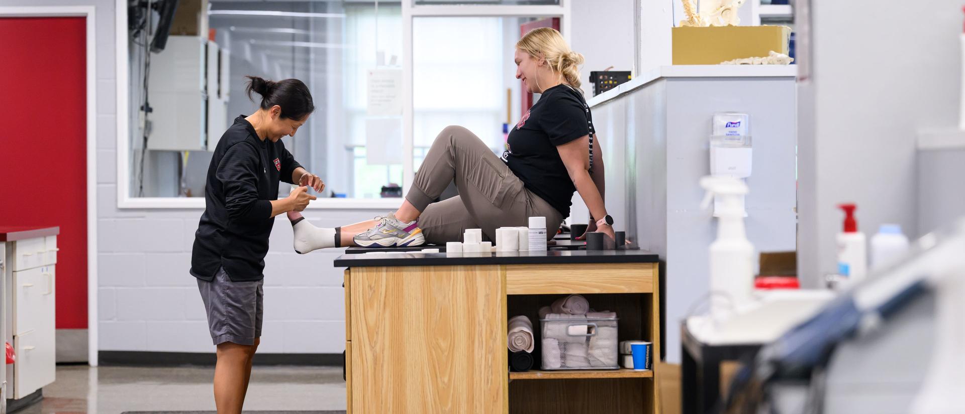 Sports trainer wrapping an athlete's foot in the Sports Medicine department